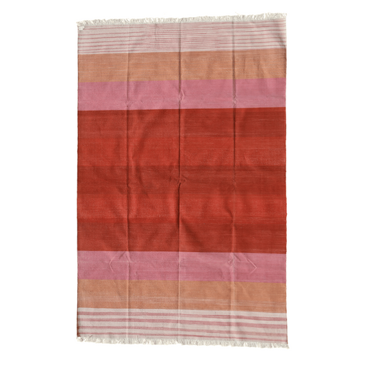 Revitalize your space with this handwoven red ombre cotton rug. Its vibrant hues transition seamlessly, infusing energy into any room. Finished with fringes for added flair, this rug brings warmth and style to your home decor.