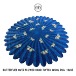 A vibrant round wool rug featuring a deep blue background with butterflies elegantly scattered over a flower-like design, perfect for enhancing the aesthetic of a bedroom or living room. Ideal as a centerpiece in living room area rugs, especially in the 8x10 size category.