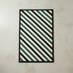 Envelop Stripes Hand Tufted Wool Rug with green and white diagonal stripes on a beige floor.