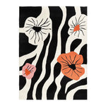 Top view of the Blossom Cascade Hand Tufted Wool Area Rug featuring a bold black and white abstract zebra pattern with vibrant orange and pink floral accents.