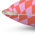 Close-up view of a Checker Groovy Throw Pillow featuring a vibrant checkered pattern in pink and orange with a zipper detail.