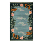 Ethereal Blossom Drift Hand Tufted Wool Area Rug featuring an abstract design with tigers, pink flowers, and swirling clouds on a rich green background.