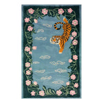 A beautifully designed area rug featuring an abstract depiction of a tiger surrounded by lush green vines and delicate pink flowers. The hand-tufted wool rug showcases a serene blue background, creating a tranquil and artistic ambiance.