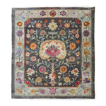Charming Heirloom Petals Classic Hand Tufted Rug displaying a vintage floral design in rich, colorful tones on a dark background. This large 8x10 area rug is perfect for adding a touch of elegance to any living room. Made from high-quality wool, it's both a floral and vintage rug that enhances the ambiance of your space.