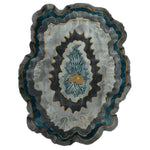 Modern living room with a blue sofa, an abstract wool rug, abstract art, and decorative items.