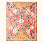 Pastel Paradise Hand Tufted Rug showcasing a vibrant floral design with pink, white, and blue flowers against a warm, vintage background. This wool area rug is perfect for adding a touch of elegance to any living room, blending seamlessly with various decor styles.