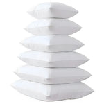 A stack of five fluffy white throw pillows, ideal for home decor and comfort.