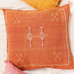 Handwoven cactus silk throw pillow cover in vibrant orange with intricate white patterns, perfect for adding a touch of bohemian style to your home decor.