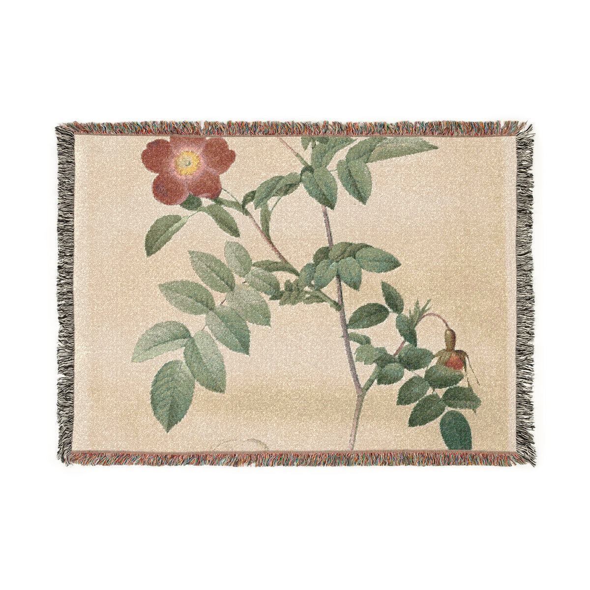 A woven throw blanket featuring a botanical rose design with green leaves, a red flower, and a hanging rose hip on a beige background, finished with fringed edges.
