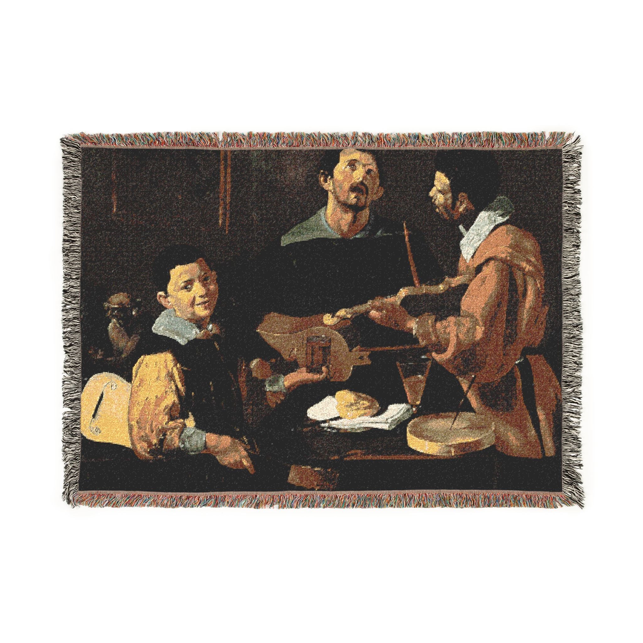 A rectangular woven tapestry with fringed edges, featuring a classical painting scene of three men gathered around a table with musical instruments and food, shown on a plain white background.
