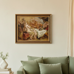 A framed classical painting depicting figures in a warm, golden-toned scene, hung on a cream wall above a sage green sofa with pillows and a small vase of flowers on a side table.