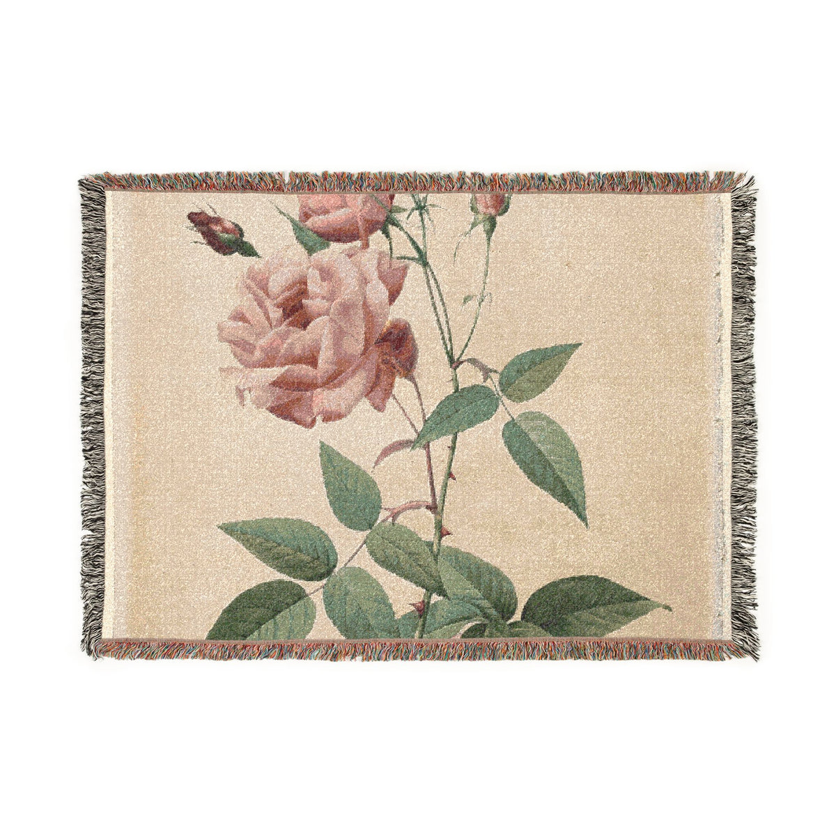 A rectangular woven throw blanket with fringed edges, featuring a vintage-style botanical print of pink roses and green leaves on a warm beige background.