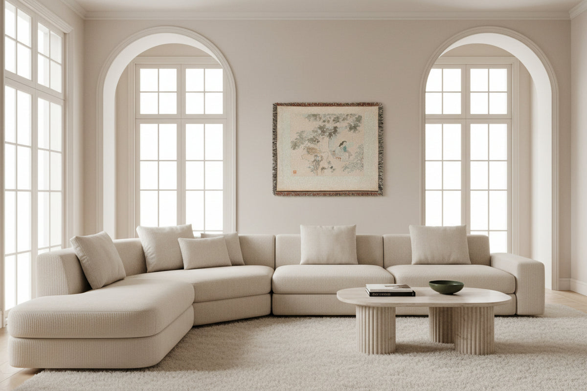 A square woven throw blanket with fringed edges, featuring a traditional Chinese-style landscape painting print of a woman sitting by a tree in soft muted tones of beige, gray, and blue.