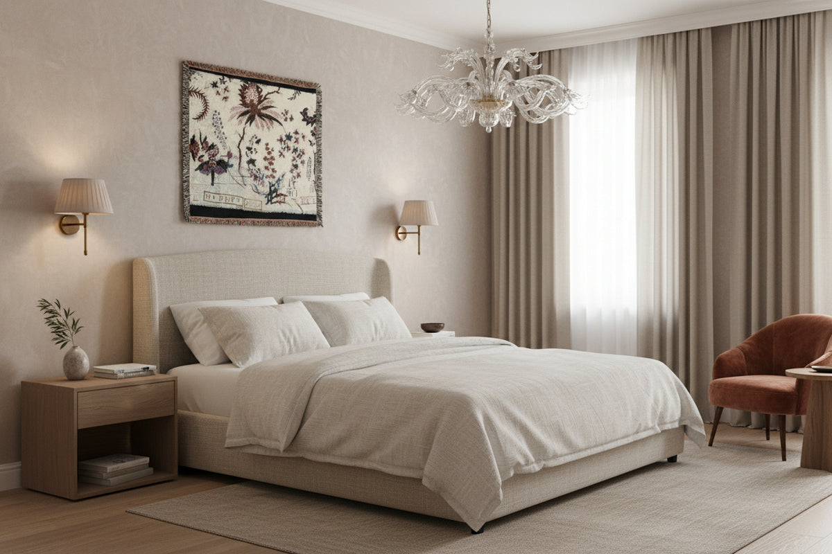 A square woven tapestry with fringed edges, featuring a cream background decorated with botanical illustrations, floral motifs, and decorative script text in muted purple, brown, and blue tones.
