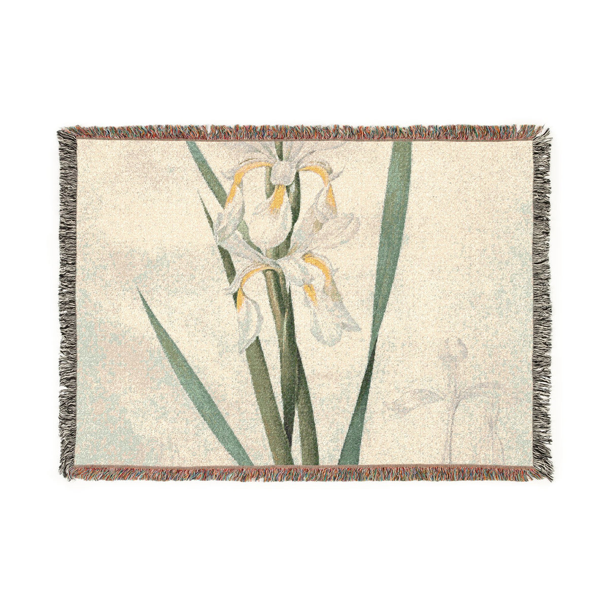 A rectangular woven throw blanket with fringe edges, featuring a botanical print of white irises with yellow centers and green leaves on a light cream background.