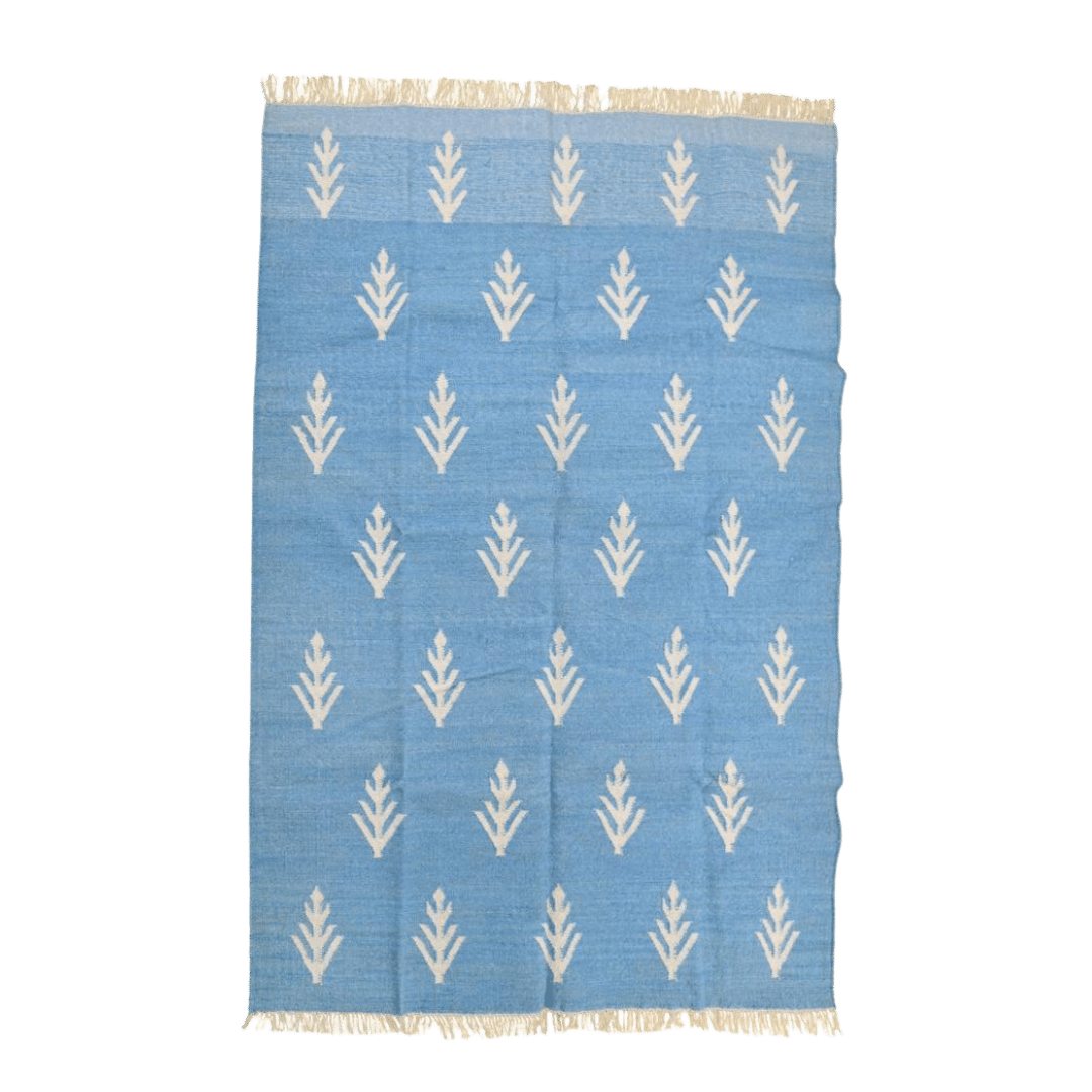 Handwoven White Floral Blue Cotton Rug with Fringes" - Infuse your space with floral elegance using this handwoven cotton rug. Delicate white florals on a serene blue background create a calming atmosphere. Finished with fringes, it adds a touch of charm to any room. Perfect for those seeking to bring a touch of nature indoors with style and grace.