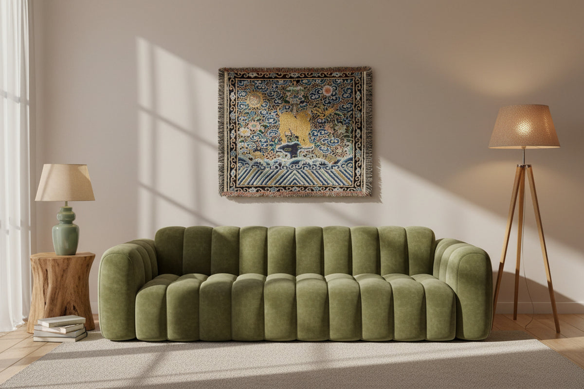 A square woven tapestry with fringed edges, featuring a central golden deer standing on stylized blue waves under a cloud-filled sky with floral and sun motifs.
