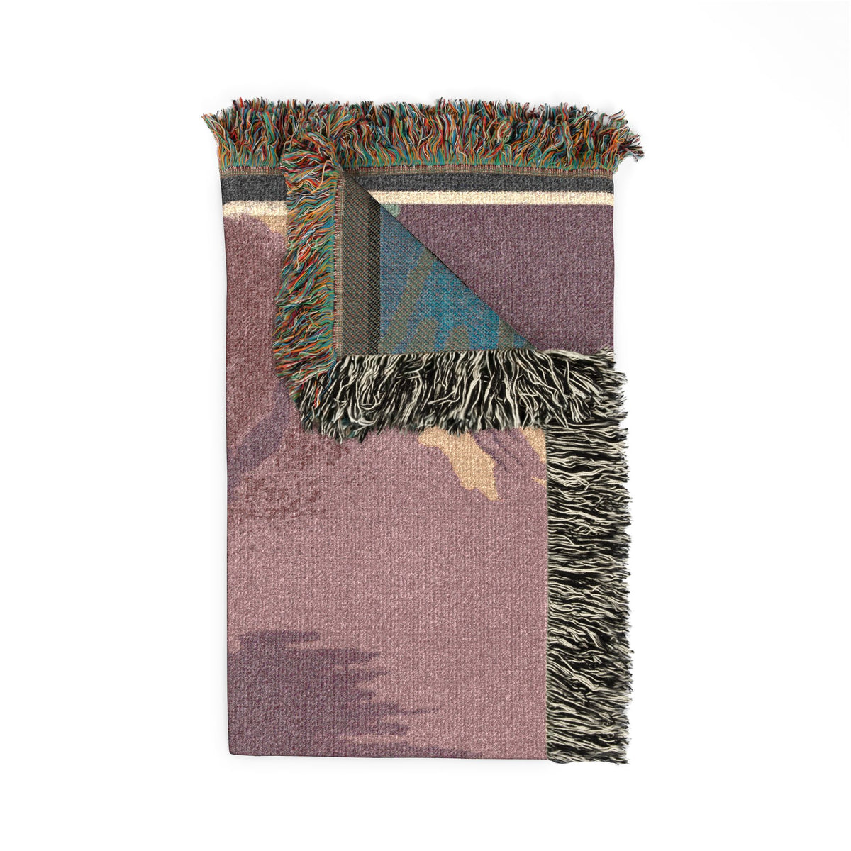 Folded corner of the See America tapestry blanket, revealing fringed edges and a mauve, purple and tan pattern.