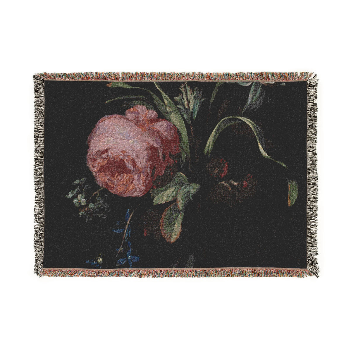 A rectangular woven throw blanket with fringe on all sides, featuring a dark floral print of a pink rose and green leaves on a black background.