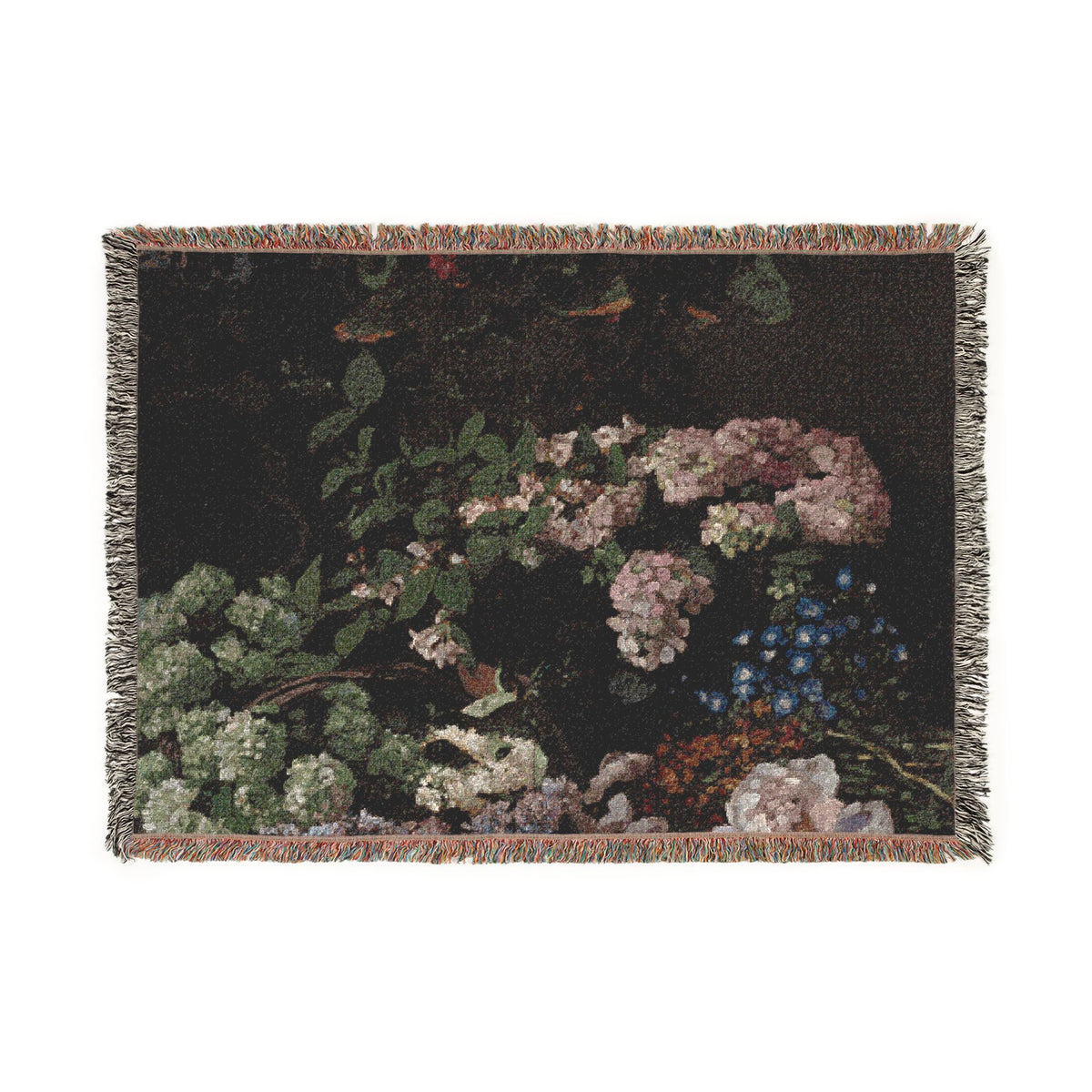 A rectangular woven throw blanket with fringed edges, featuring a dark floral design with pink, white, green, and blue flowers on a black background.