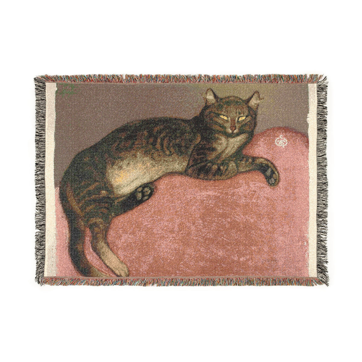 A rectangular woven throw blanket with fringed edges, featuring a detailed illustration of a brown tabby cat lying on a dusty pink cushion against a taupe background.