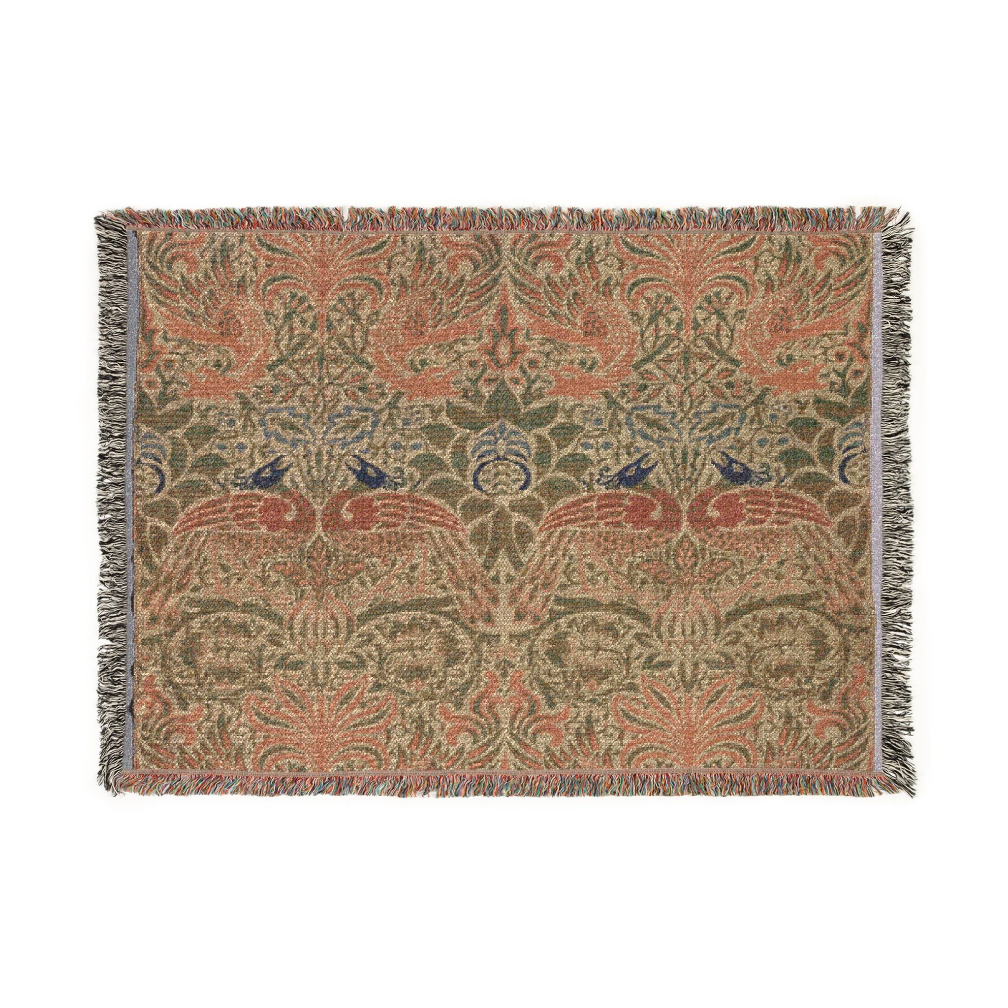 A rectangular woven textile with fringe on all sides, featuring an intricate botanical and bird pattern in muted green, terracotta, beige, and blue tones, shown flat against a white background.