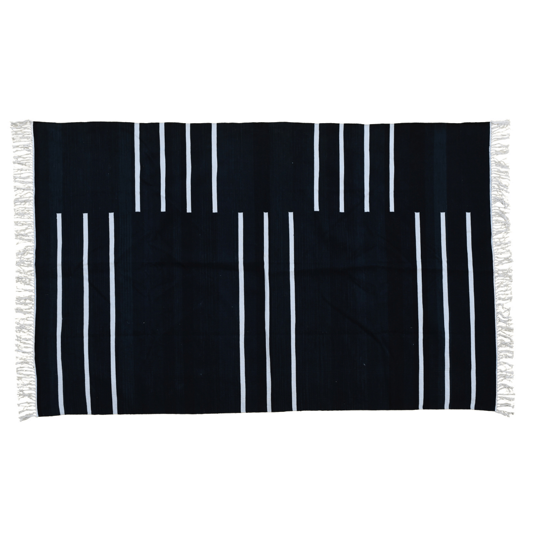 Add a touch of modern elegance to your space with the "Handwoven Black and White Minimalistic Stripe Cotton Rug with Fringes." Its clean lines and minimalist design in black and white hues exude sophistication and charm, while the fringes add a subtle yet stylish detail. Handcrafted with care, this rug brings both contemporary flair and comfort to any room in your home.