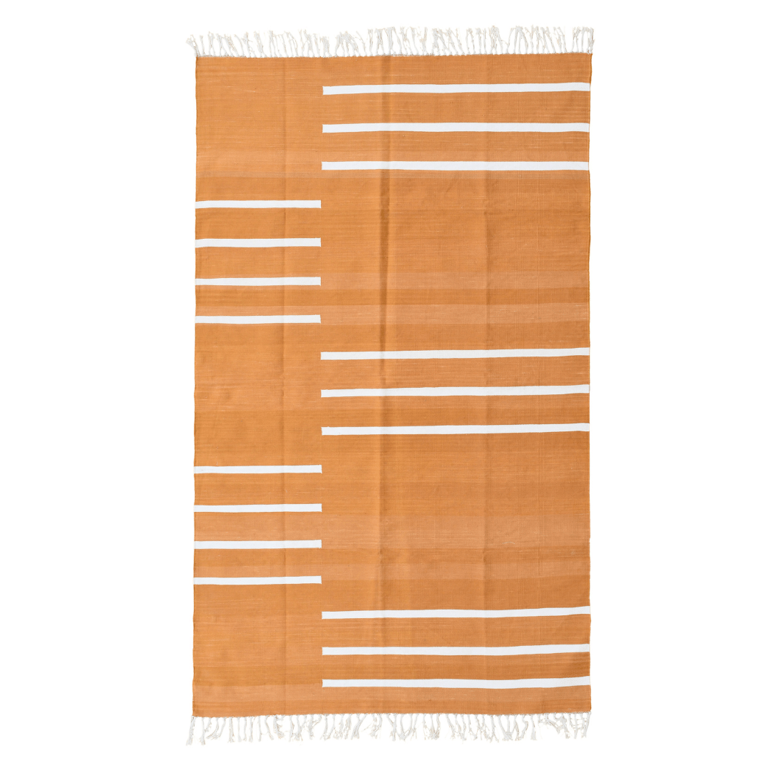 Elevate your space with the vibrant charm of the "Handwoven Turmeric and White Minimalistic Stripe Cotton Rug with Fringes." Its bold turmeric hue paired with clean white stripes exudes modern sophistication, while the fringes add a playful touch. Handcrafted with care, this rug brings both style and comfort to any room in your home, creating a welcoming atmosphere with its warm and contemporary aesthetic