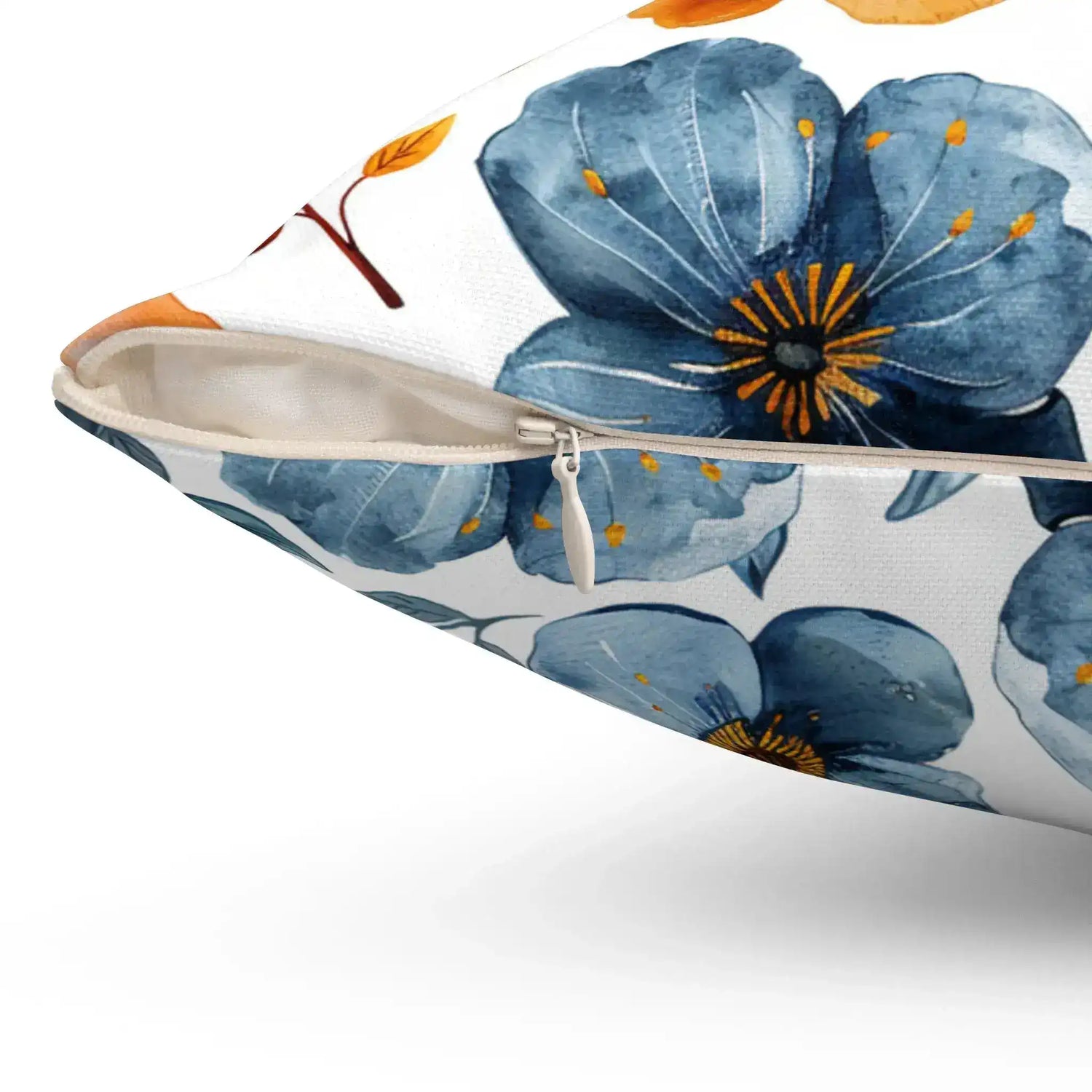 Close-up view of a decorative throw pillow featuring a floral design with blue flowers and autumn leaves, showcasing a zipper detail.