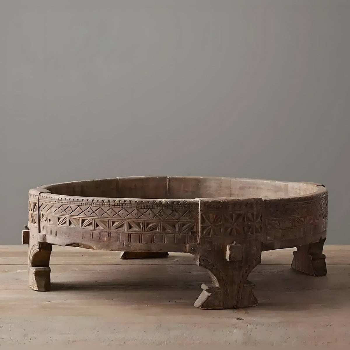 Hand-carved wooden chakki table with geometric tribal carvings and short legs