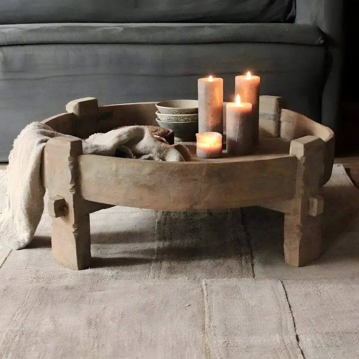 Bahamas wooden chakki table styled with lit pillar candles and carved bowls