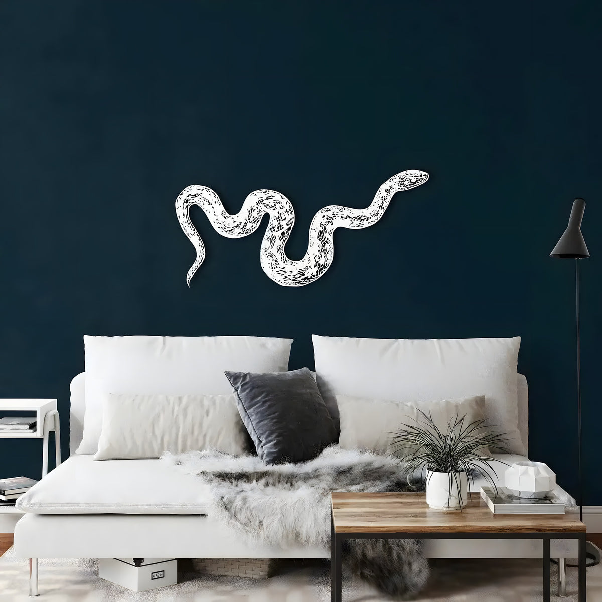 White metal snake wall art curving across a dark navy wall above a white daybed