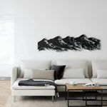 Black five-peak mountain range metal wall art on a white wall above a white sectional