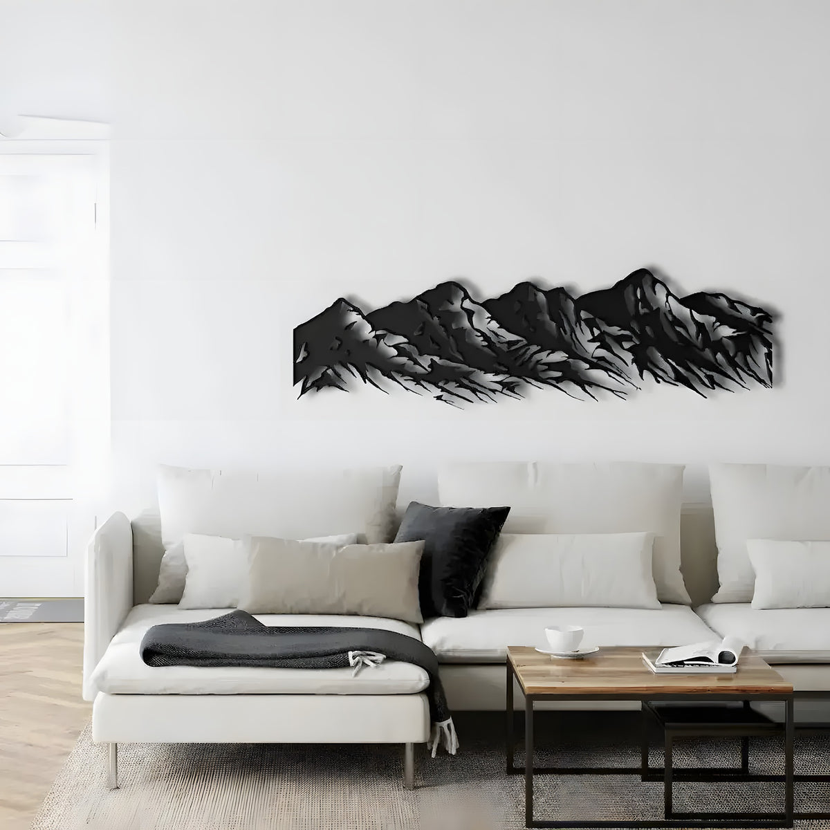 Black five-peak mountain range metal wall art on a white wall above a white sectional