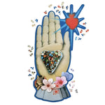 Assembled Maison de Jeu shaped jigsaw puzzle of an ornate open palm holding a jeweled heart and radiant red heart