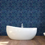 Art deco blue scallops wallpaper with gold-outlined fan shapes behind a white freestanding bathtub