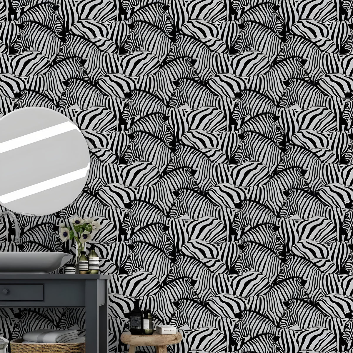 Black and white zebra wallpaper behind a dark bathroom vanity with round mirror