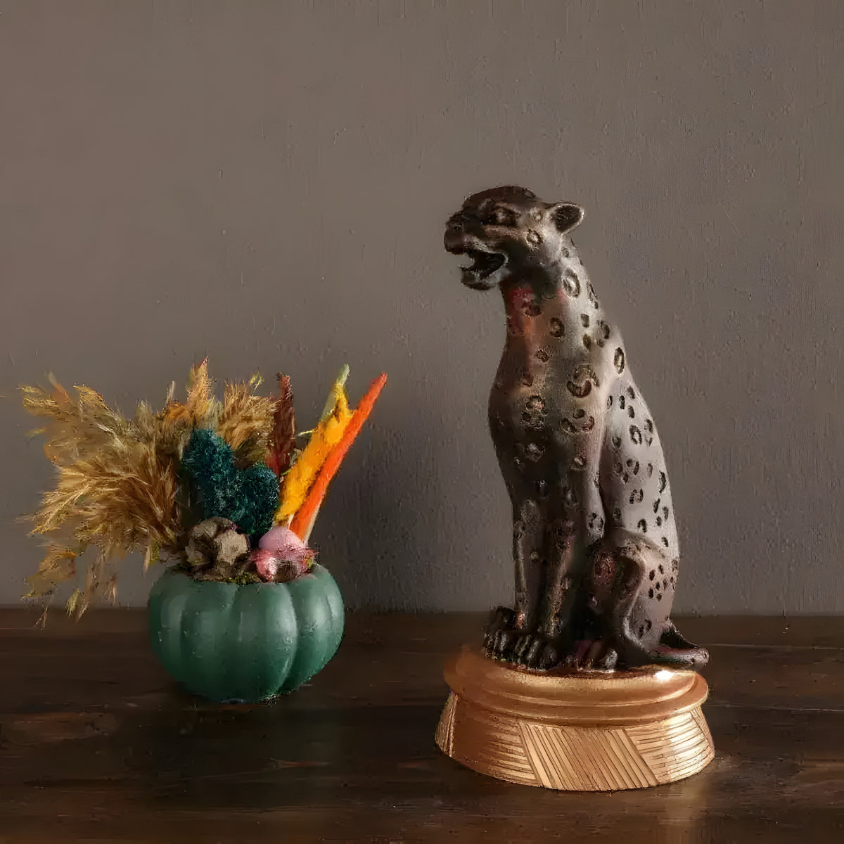 Bronze panther sculpture seated and roaring with etched spots on a gold plinth