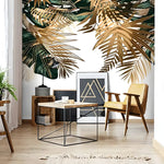 Gold and green palm leaf mural behind yellow armchair and wood coffee table