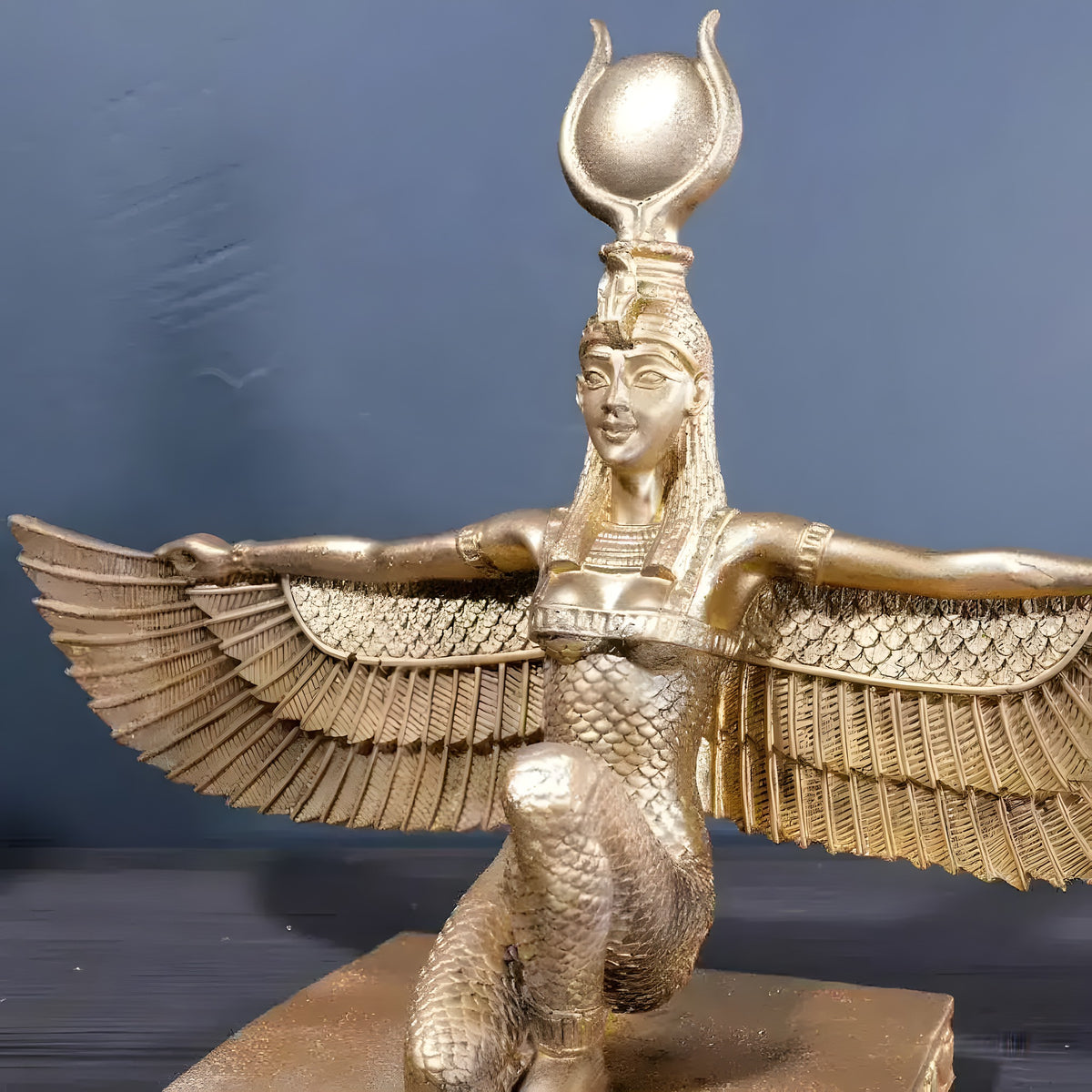 Gold kneeling Isis goddess sculpture with spread wings and horned sun-disc crown, three-quarter view
