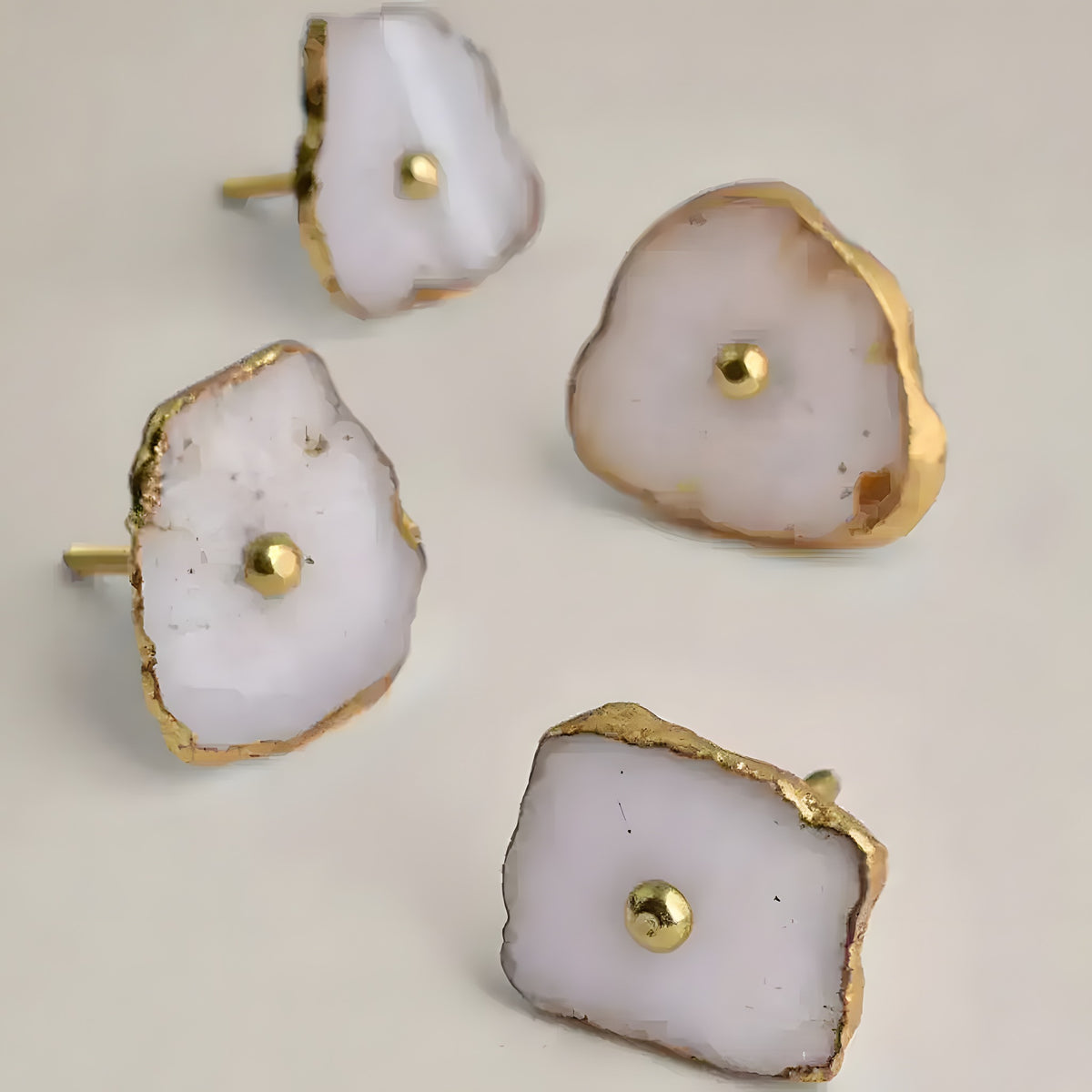 Four white agate stone cabinet knobs with raw gold-gilded edges and brass center posts