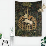 Unicorn in Captivity tapestry showing a white unicorn in a wooden fence amid foliage