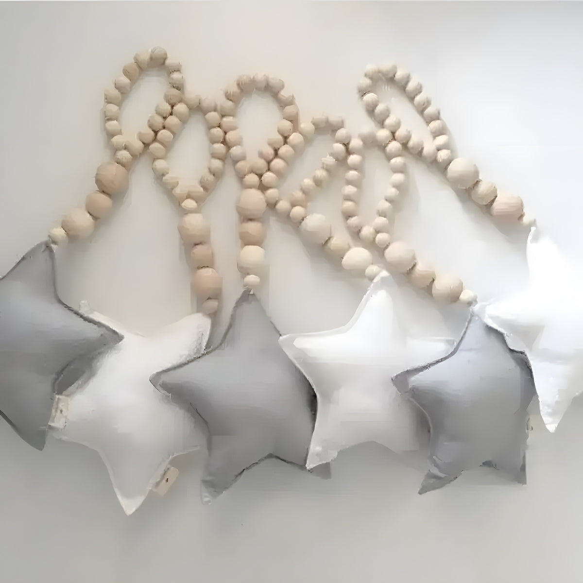 Gray, white and charcoal fabric star ornaments hung from natural wooden bead strands