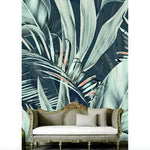 Large-scale teal botanical tropical leaf wallpaper mural with ornate gold-framed sofa beneath