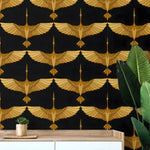 Close-up of art deco gold crane wallpaper — symmetrical gold flying cranes on black, over wood sideboard