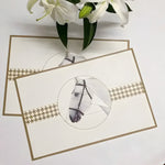 Two cream faux leather plate mats with vintage horse portrait print in circle and gold houndstooth band