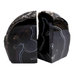 Pair of black geode crystal bookends with polished dark agate faces and white banding, rough natural exterior