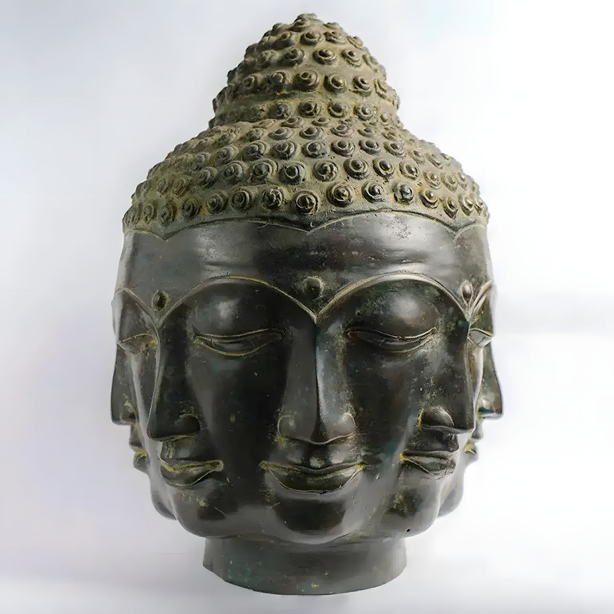 Large dark bronze single Buddha head with three faces and spiral topknot, front close-up