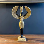 Egyptian Goddess Isis sculpture, full front view, black body, gold feathered wings spread, arms raised holding orb, inscribed base