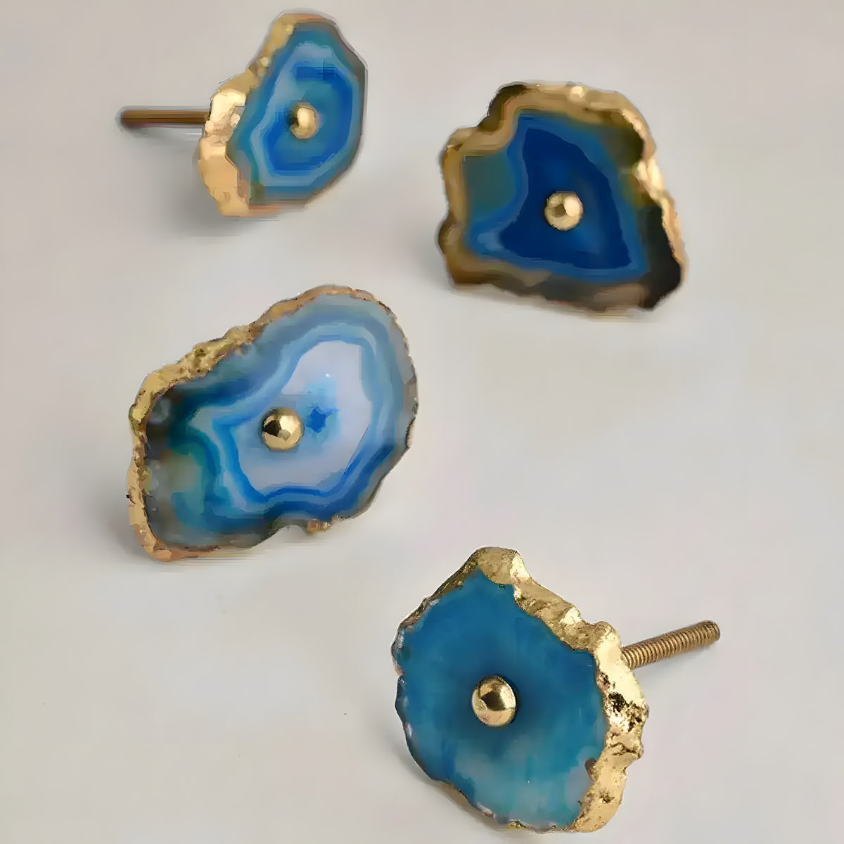 Set of four blue agate stone knobs with gold irregular rims and gold posts, each unique in shape
